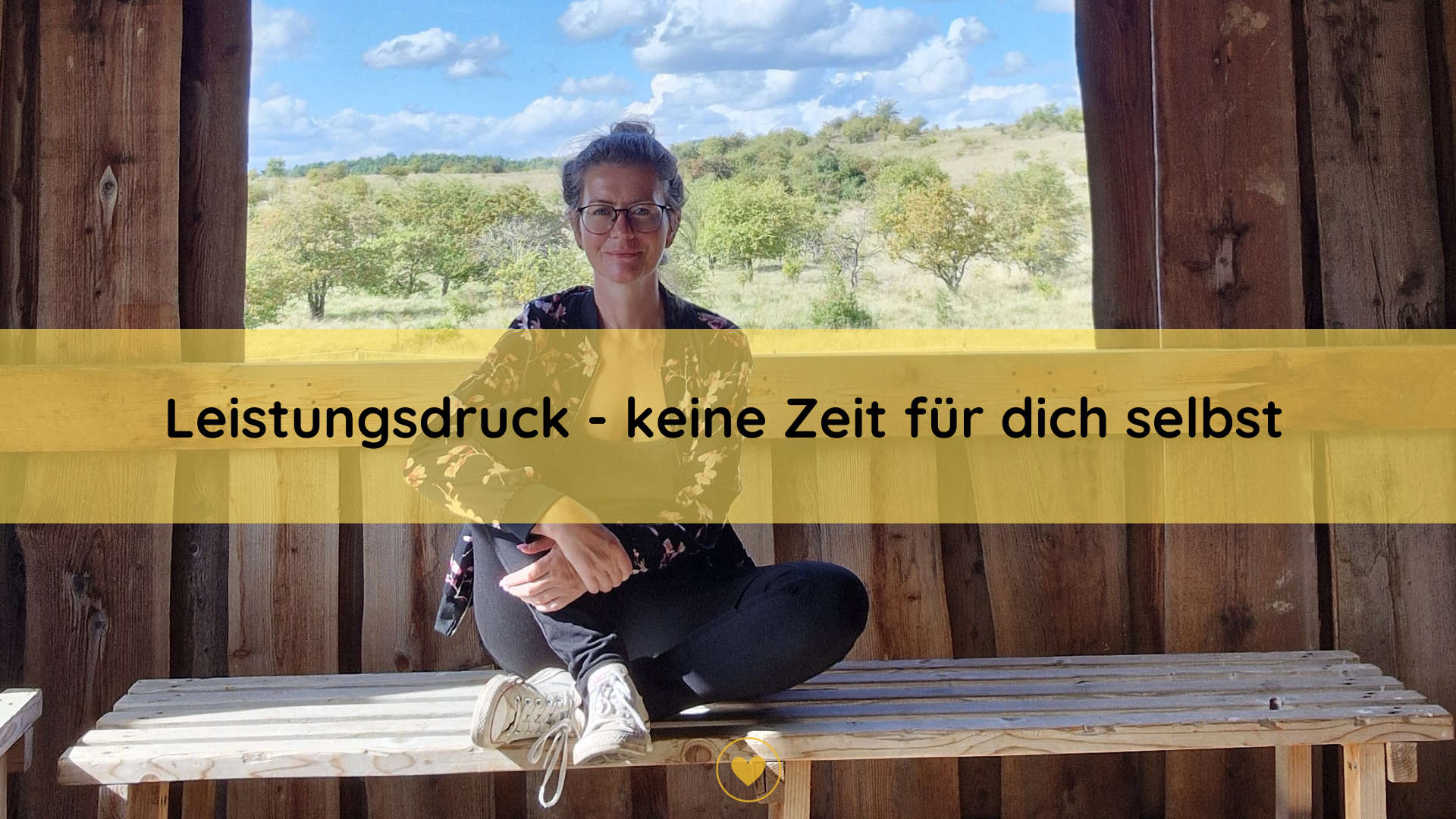 Person in einer Holzhütte und hinter ihr der Ausblick auf die Landschaft.